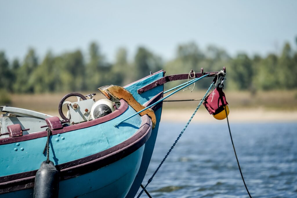 A closeup of a blue sailing boat parked in the water