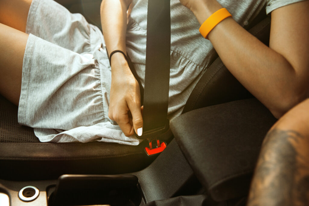 Young couple preparing for vacation trip on the car in sunny day. Woman and man sitting and ready for going to sea, riverside or ocean. Concept of relationship, vacation, summer, holiday, weekend.